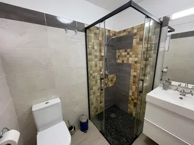 a bathroom with a shower and a toilet and a sink at Casa Luztour in Luz
