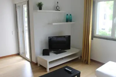 a living room with a tv on a white table at Jasmineiro - Palms Palace Apartment in Funchal