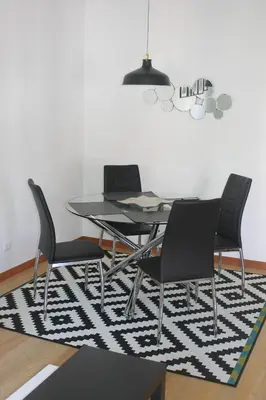 a dining room with a table and chairs on a rug at Jasmineiro - Palms Palace Apartment in Funchal