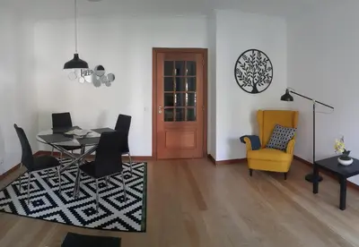 a living room with a table and a yellow chair at Jasmineiro - Palms Palace Apartment in Funchal