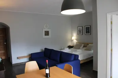 a living room with a blue couch and a bed at Magnoliamar 304 in Lagos