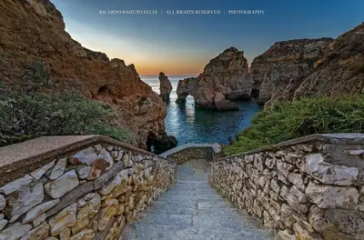 a stairway leading down to the water with a rock wall at Magnoliamar 304 in Lagos