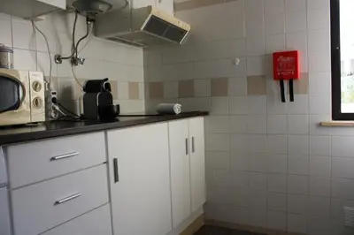 a kitchen with white cabinets and a microwave at Magnoliamar 304 in Lagos