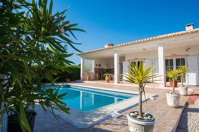 a villa with a swimming pool in front of a house at Casa Naboo - Sunny Holiday Home with Pool in Aljezur