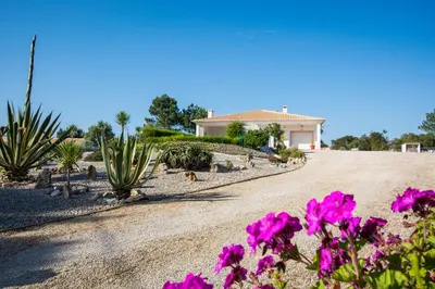 a house on a dirt road with flowers at Casa Naboo - Sunny Holiday Home with Pool in Aljezur