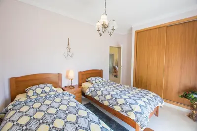 a bedroom with two beds and a chandelier at Casa Naboo - Sunny Holiday Home with Pool in Aljezur
