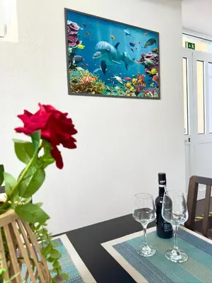a vase with red roses on a table in a living room at O Cantinho do Zé in Funchal