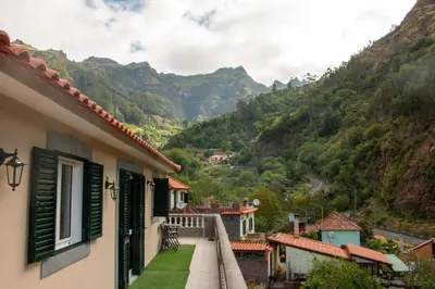 a balcony of a house with mountains in the background at Danny's Rural Suite in Curral das Freiras