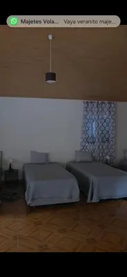 two beds sitting in a room with avertisement at Danny's Rural Suite in Curral das Freiras