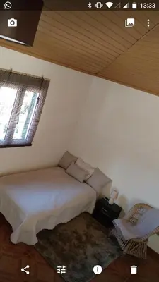 a bedroom with a bed and two windows in a room at Danny's Rural Suite in Curral das Freiras