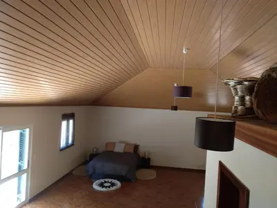 a bedroom with a bed and a wooden ceiling at Danny's Rural Suite in Curral das Freiras