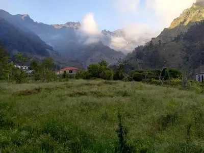 a field of grass with mountains in the background at Danny's Rural Suite in Curral das Freiras