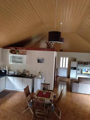 a kitchen and living room with a table and chairs at Danny's Rural Suite in Curral das Freiras