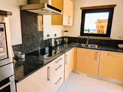 a kitchen with black counter tops and a sink at Luxury 3-bedroom apartment at high-end Praia da Luz in Luz