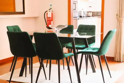 a dining room with a glass table and green chairs at Luxury 3-bedroom apartment at high-end Praia da Luz in Luz