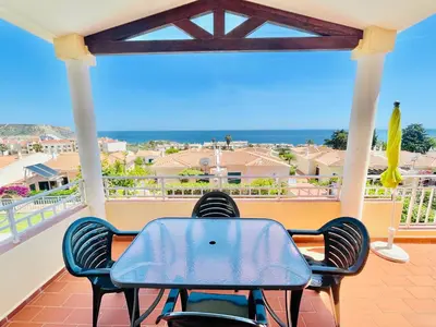 a table and chairs on a balcony with a view of the ocean at Villa Acacias 13 in Luz