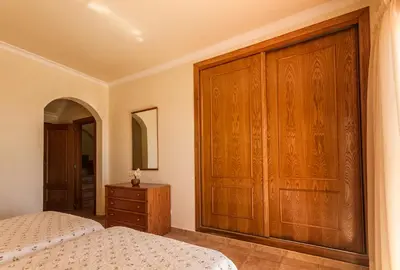a bedroom with two beds and a wooden closet at Villa Acacias 13 in Luz