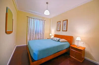 a bedroom with a blue bed and a window at Sol & Mar Camara de Lobos in Câmara de Lobos