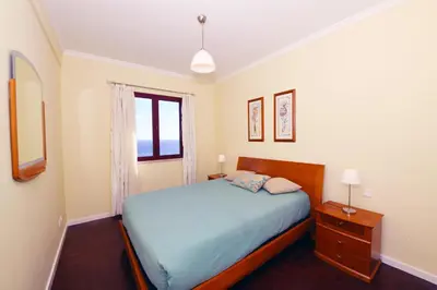a bedroom with a bed and a window at Sol & Mar Camara de Lobos in Câmara de Lobos