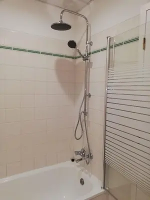 a bathroom with a shower and a bath tub with a shower head at Sol & Mar Camara de Lobos in Câmara de Lobos