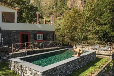 a woman on a horse standing next to a swimming pool at Casas do Lanço by An Island Apart in São Vicente