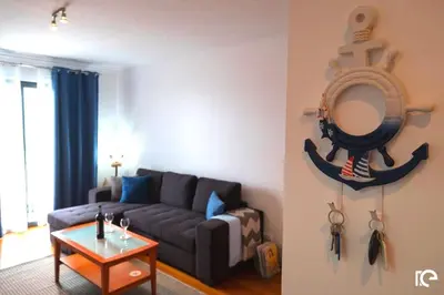 a living room with a couch and a mirror at Apartamento Estefânia in Santa Cruz