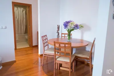 a dining room table with a vase of flowers on it at Apartamento Estefânia in Santa Cruz