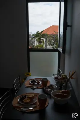 a table with plates of food on it with a window at Apartamento Estefânia in Santa Cruz