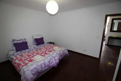a bedroom with a bed with a red and purple blanket at Portinho II-Modern apt with balcony facing the sea in Caniço