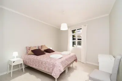 a white bedroom with a bed and a chair at Villa Ponta do Sol Apartment in Ponta do Sol