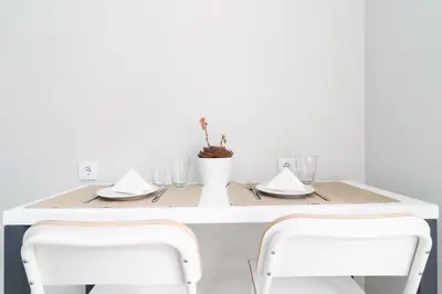 a white table with two white chairs and a table with glasses at Villa Ponta do Sol Apartment in Ponta do Sol
