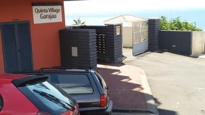 a red car parked in front of a building at Garajau Elite in Caniço