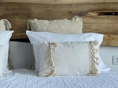 a bed with white pillows and a wooden headboard at ModuLAR in Calheta