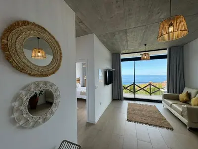 a living room with a couch and a mirror at ModuLAR in Calheta