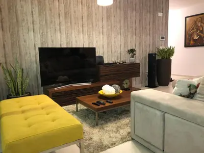 a living room with a television and a couch at Villa Palheiros in Arco da Calheta