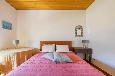 a bedroom with a large bed with a pink blanket at Casa Lua in Sagres