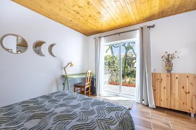 a bedroom with a bed and a sliding glass door at Casa Lua in Sagres