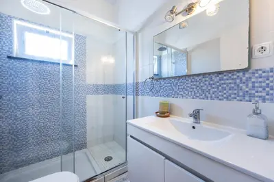 a bathroom with a shower and a sink and a mirror at Casa Lua in Sagres