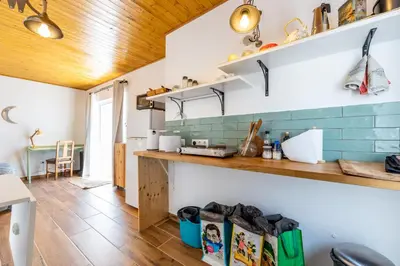 a kitchen with white walls and a wooden ceiling at Casa Lua in Sagres