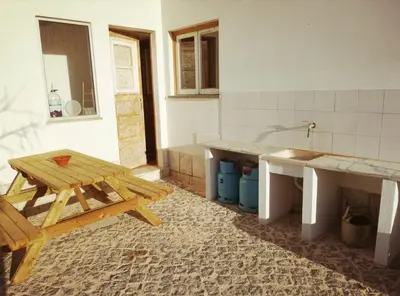 a kitchen with a wooden picnic table and a sink at Casa Lua in Sagres