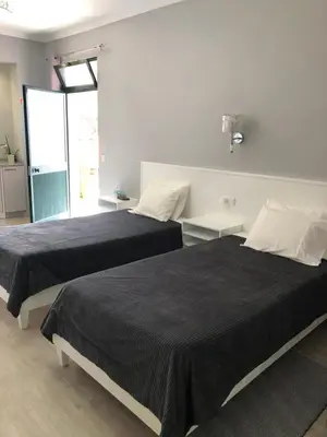 two beds in a white room with black sheets at STUDIO'S HOUSE in Funchal