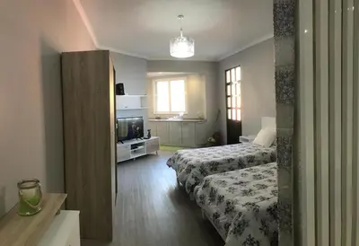 a hotel room with two beds and a television at STUDIO'S HOUSE in Funchal