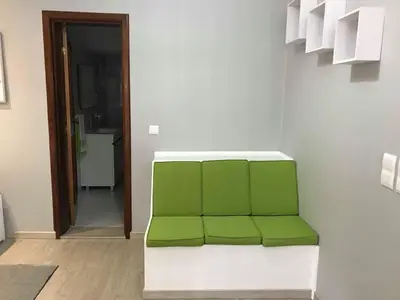 a green bench sitting in a room with a hallway at STUDIO'S HOUSE in Funchal
