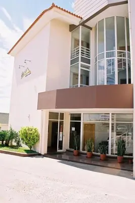 a large white building with potted plants in front of it at Areia Dourada in Porto Santo