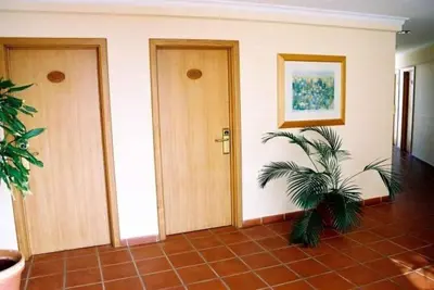 a hallway with two doors and a plant in it at Areia Dourada in Porto Santo