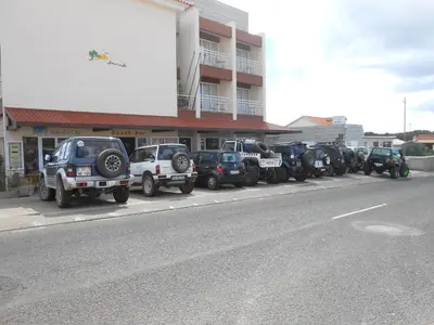 a row of vehicles parked in front of a building at Areia Dourada in Porto Santo