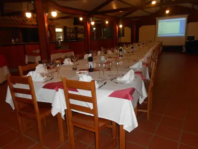 a long dining room with a long table with wine glasses at Areia Dourada in Porto Santo