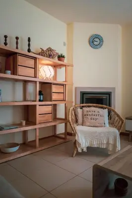 a living room with a chair and a fireplace at Casa Laranja, Aromas Burgau in Burgau