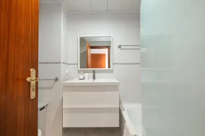 a white bathroom with a sink and a mirror at Piornais by Homie in Funchal