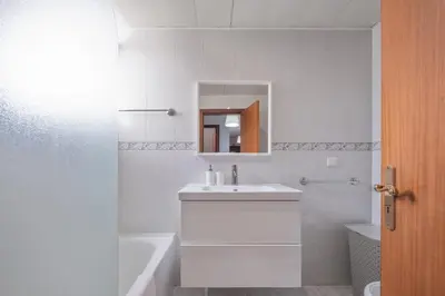 a white bathroom with a sink and a bath tub at Piornais by Homie in Funchal